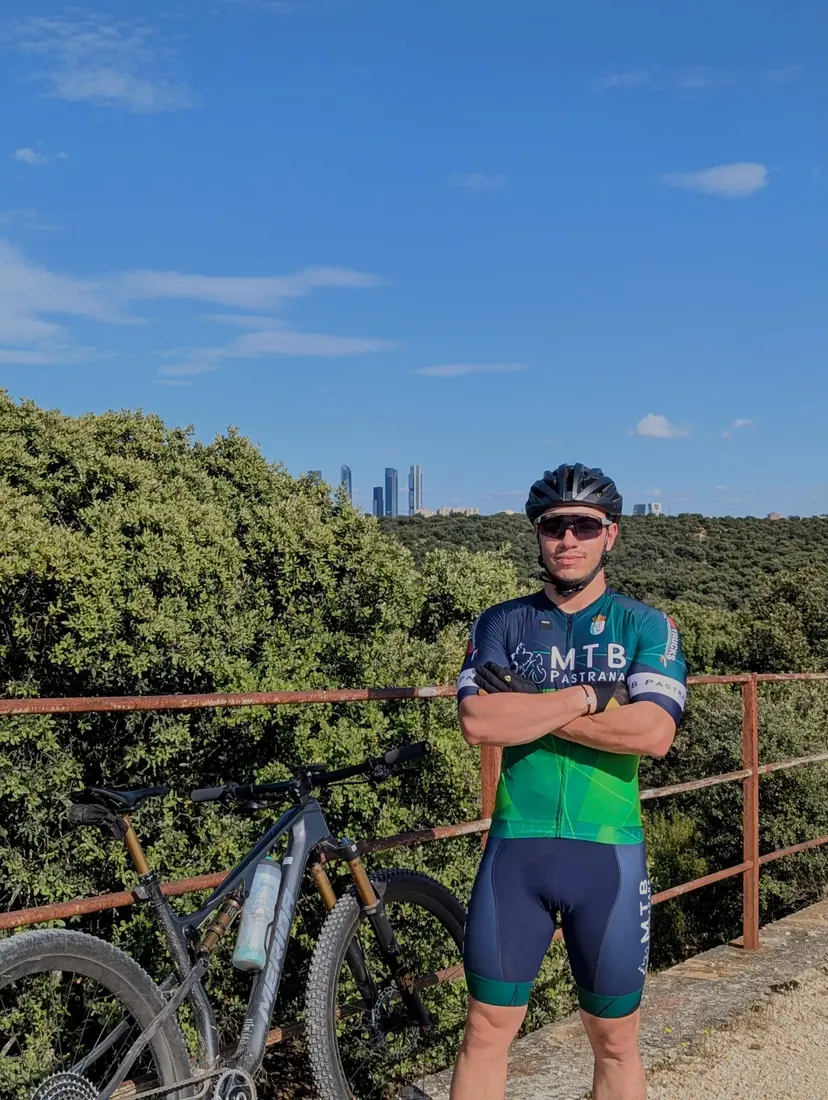 Ángel, fundador de CampaMTB, con su bicicleta y el perfil de Madrid al fondo