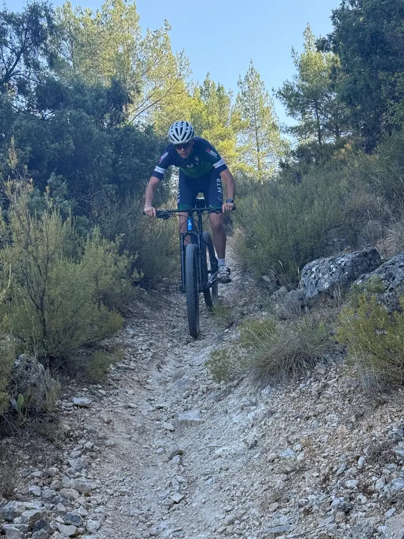 Ciclista subiendo un sendero pedregoso durante una clase particular