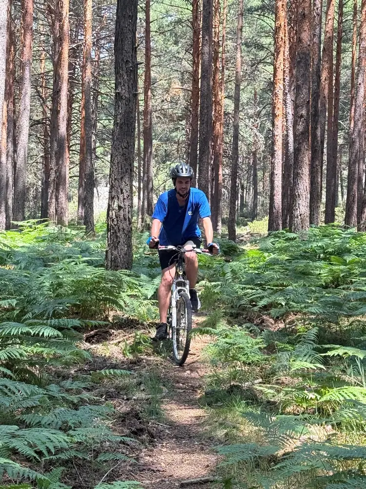 Joven rodando por un sendero entre helechos
